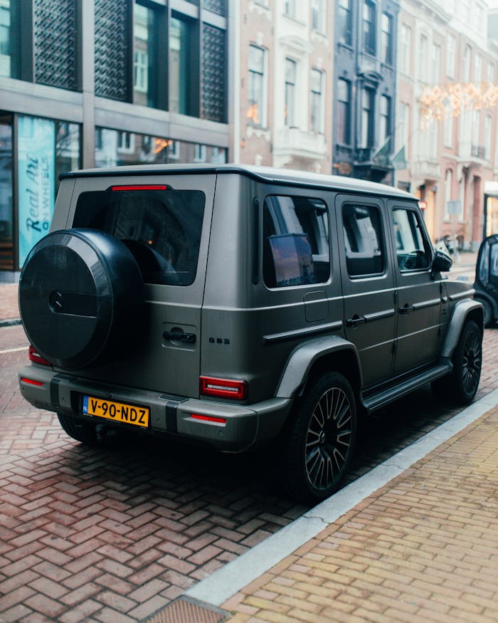 Luxury SUV parked on a cobblestone urban street, capturing a stylish city vibe.